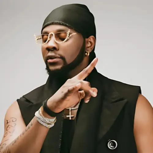 Picture of Kizz Daniel wearing a black sleeveless outfit, durag and diamond studded accessories 