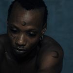 EF Moon, Nigerian Afro-fusion artist, with his signature crescent moon forehead tattoo and facial marks