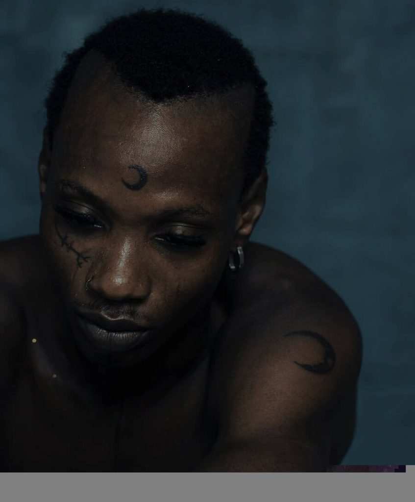 EF Moon, Nigerian Afro-fusion artist, with his signature crescent moon forehead tattoo and facial marks